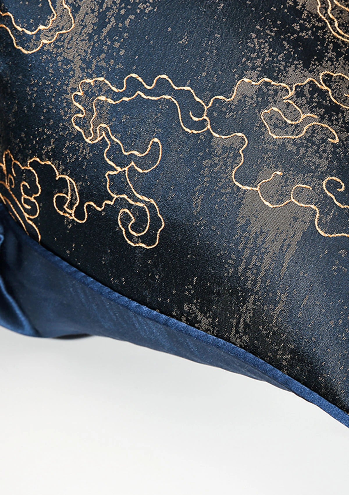 Close-up view of a navy cushion cover with gold accents